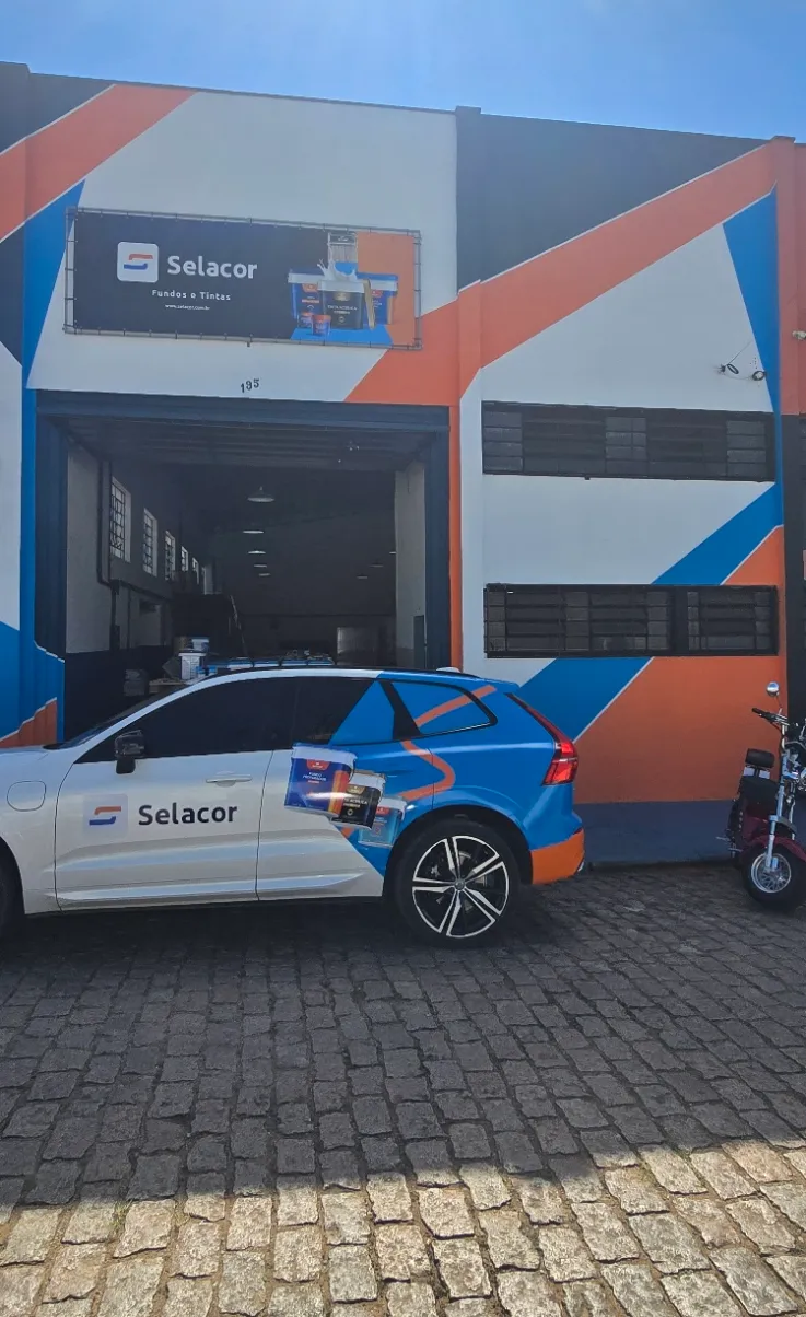 Fachada da fábrica da Selacor em Itatiba, pintada com a identidade da marca, com o carro de entrega adesivado na frente
